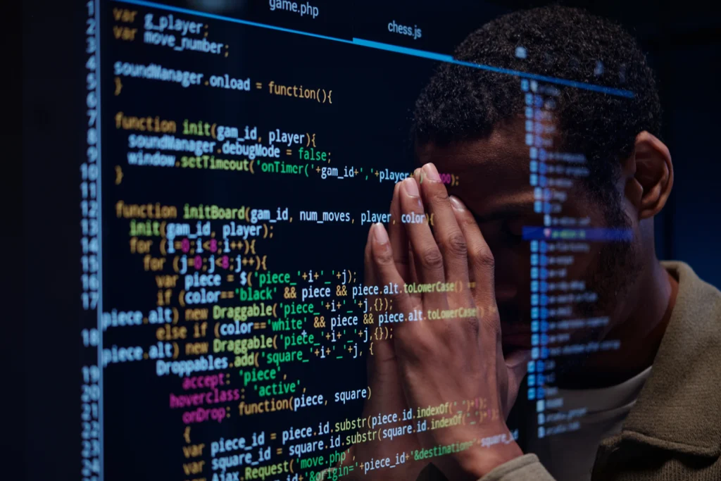 Mão de um homem negro em cima de uma tela preta representando códigos de TI neste caso o Gemini no Code
